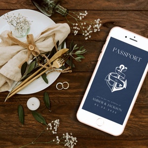 May include: A navy blue phone screen with a white anchor and ribbon with the text "PASSPORT" and "Join us for the wedding of Amber & Jackson 05.03.2023".