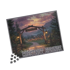 Puede incluir: Un rompecabezas con un paisaje escénico con un arco de madera que dice "Wishing Well". El rompecabezas representa un camino que conduce a un pueblo, con el texto "Greetings From CHESTNUT SPRINGS" en la parte inferior. El rompecabezas está parcialmente montado.