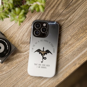 Może przedstawiać: Etui na smartfona z motywem smoka i napisem "I AM THE SKY & THE POWER OF EVERY STORM THAT HAS EVER BEEN I AM INFINITE." Etui ma czarną ramkę i gradientowe tło w kolorze szarym i białym.