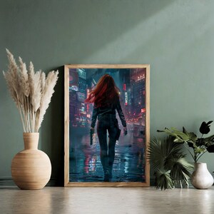 May include: A framed print of a woman with red hair walking down a neon-lit city street at night. The woman is wearing a black leather jacket and jeans. The city is full of tall buildings and bright lights.