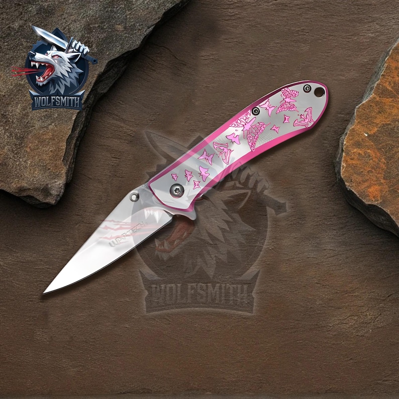 Pu&ograve; includere: Un coltello tascabile pieghevole con una lama argentata e un manico rosa. Il manico presenta un disegno a farfalla. Il coltello &egrave; prodotto da Wolfsmith.