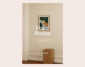 Puede incluir: Una obra de arte enmarcada con un gato en un marco de madera está montada en una pared beige. La obra de arte está encima de un pequeño cubo de madera. El texto "Frame Mockup" se muestra en la pared.
