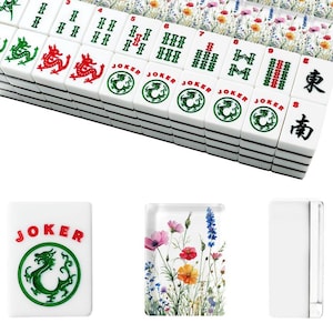 May include: A set of white Mahjong tiles with black markings and colorful floral accents. The tiles feature Chinese characters, dragons, and the word "JOKER". The set includes tiles with numbers and suits.