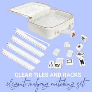 May include: White mahjong set with clear tiles and racks. The set includes a white case with a clear top, tiles, and racks. The text on the image reads "CLEAR TILES AND RACKS elegant mahjong matching set."