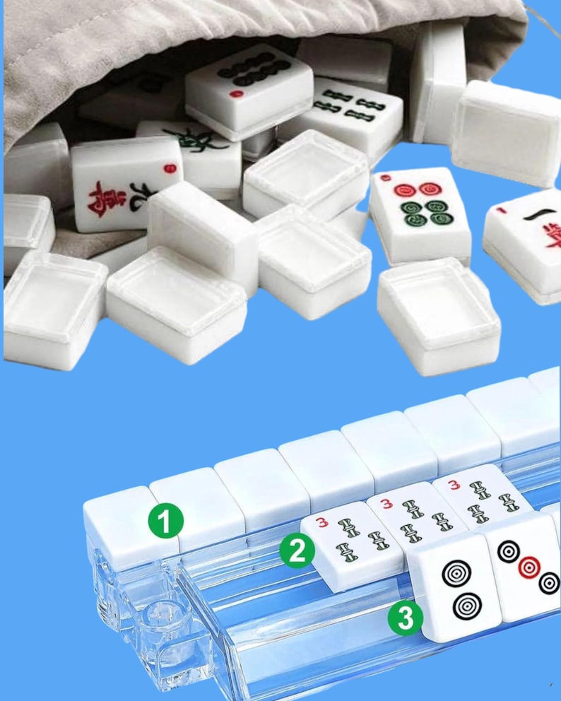 May include: A white Mahjong set with various symbols and numbers, including red and green markings. The tiles are displayed in a clear plastic rack and a beige cloth bag. The game set is on a blue background.