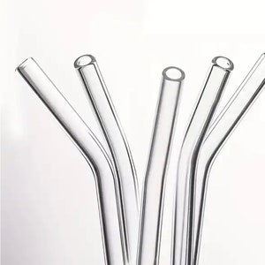 May include: A set of six clear glass drinking straws with a slight bend at the top. The straws are arranged in a fan shape.
