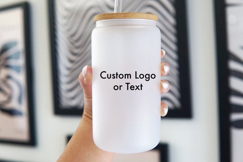 May include: White frosted glass tumbler with a wooden lid and a straw. The tumbler has the text "Custom Logo or Text" printed on the front.
