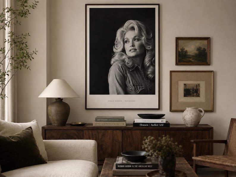 May include: A large black and white portrait print of Dolly Parton in a dark frame hanging on a wall. The photograph features the subject with voluminous hair, wearing a collared shirt, with the text Dolly Parton Tennessee printed at the bottom.