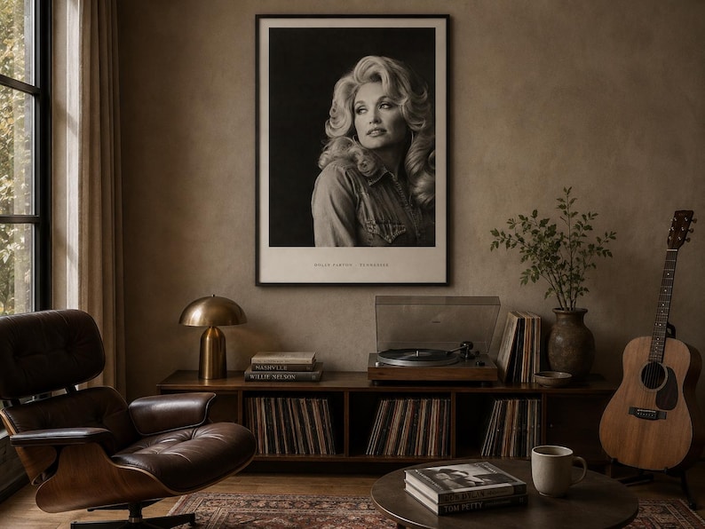 May include: A black and white framed portrait print of Dolly Parton hanging on a wall. The print features a photograph of the artist with the text DOLLY PARTON - TENNESSEE printed in a clean, sans-serif font at the bottom of the white border.