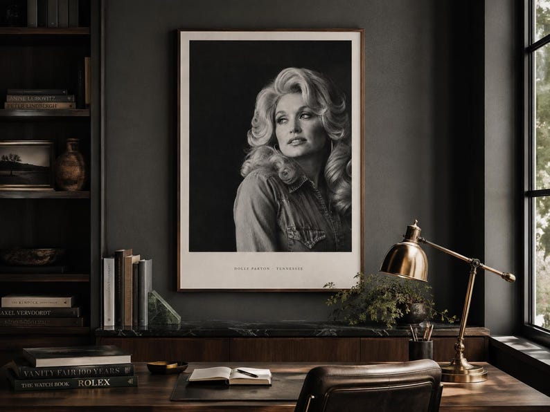 May include: A black and white portrait print of Dolly Parton in a collared shirt, featuring voluminous blonde hair and a side-facing gaze. The print is framed in a thin wooden border with the text Dolly Parton - Tennessee printed at the bottom.