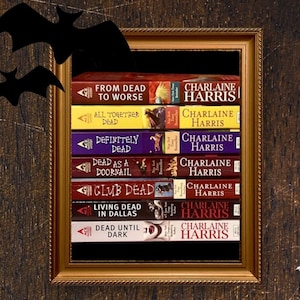 May include: A stack of Charlaine Harris books, including "From Dead to Worse" and "Dead Until Dark," displayed within a gold framed picture. The book spines are various colors, with the author's name prominently displayed.