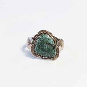 May include: A silver bracelet with a turquoise stone set in a decorative silver frame.