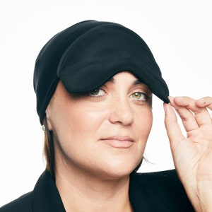 May include: A black sleep mask with a contoured design to fit comfortably over the eyes. The mask is made of a soft, breathable fabric and is designed to block out light for a restful sleep.