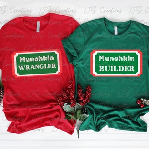 Op de afbeelding: Twee rode en groene t-shirts met een witte rand en rode en witte tekst. Het rode shirt zegt "Munchkin Wrangler" en het groene shirt zegt "Munchkin Builder".
