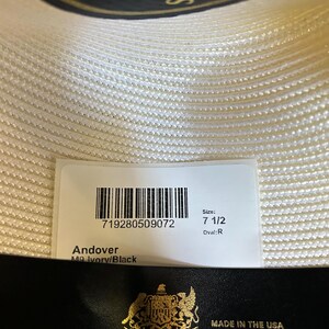 Puede incluir: Sombrero Stetson Andover marfil y negro, talla 7 1/2, forma ovalada R. La etiqueta dice "Made in the USA" e incluye el logotipo de John B. Stetson Company.
