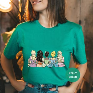a woman wearing a green t - shirt with cartoon characters on it