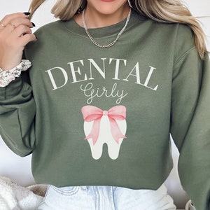 May include: A green sweatshirt with the text "Dental Girly" and a pink bow on a white tooth graphic.