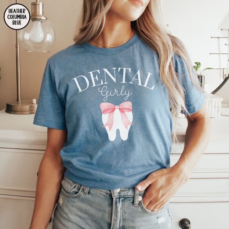 May include: A blue t-shirt with the text "Dental Girly" and a white tooth with a pink bow on it.