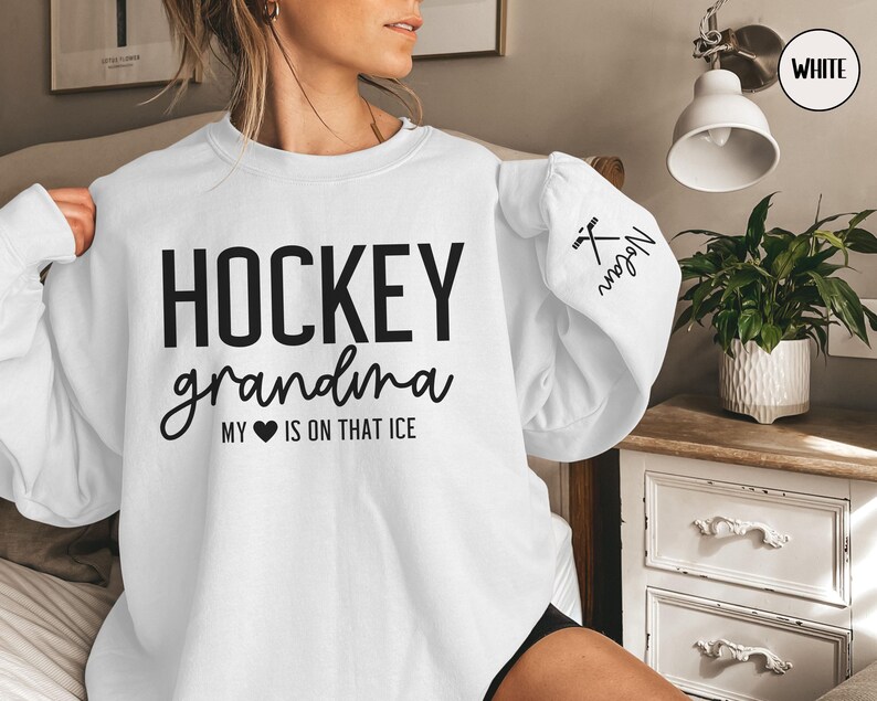 May include: White sweatshirt with the text "HOCKEY grandma MY &hearts; IS ON THAT ICE" and a hockey stick and puck graphic on the sleeve.
