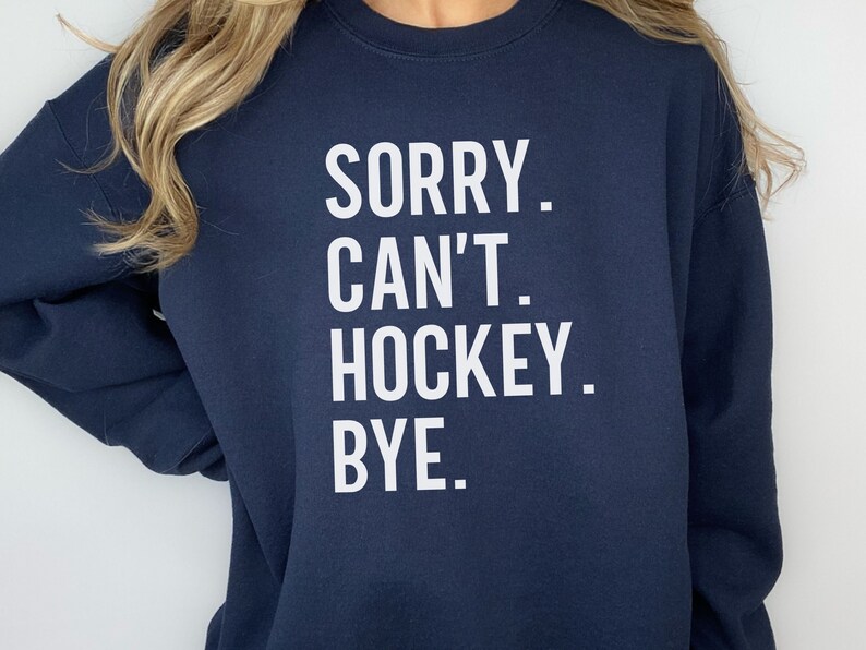 May include: Navy blue sweatshirt with white text that reads "SORRY. CAN'T. HOCKEY. BYE."