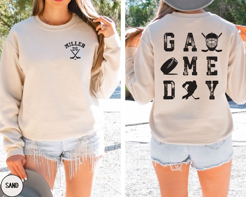 May include: A beige sweatshirt with the text "MILLER 26" on the front and "GAME DAY" with hockey-related graphics on the back.