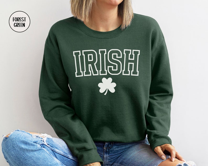 Op de afbeelding: Bosgroen sweatshirt met witte tekst "IRISH" en een wit klavertje vier.