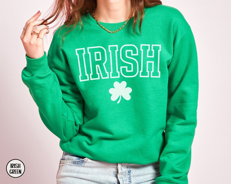 Op de afbeelding: Groen sweatshirt met het woord "IRISH" in witte letters en een wit klavertje vier.