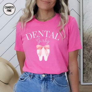 May include: Pink t-shirt with the text "DENTAL Girly" and a pink bow on a white tooth graphic.