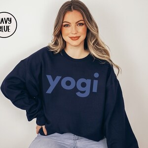 Może przedstawiać: Szarfa w kolorze granatowym z nadrukiem słowa "yogi" w jasnoniebieskim kolorze z przodu.