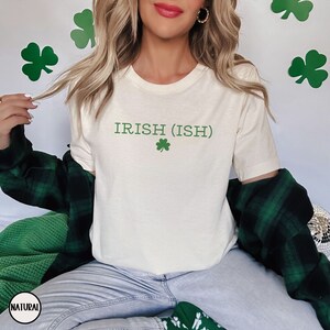 May include: A white t-shirt with the text "IRISH (ISH)" and a green shamrock printed on the front.