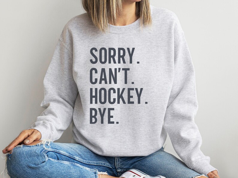 May include: Gray sweatshirt with the text "SORRY. CAN'T. HOCKEY. BYE." printed in dark gray.