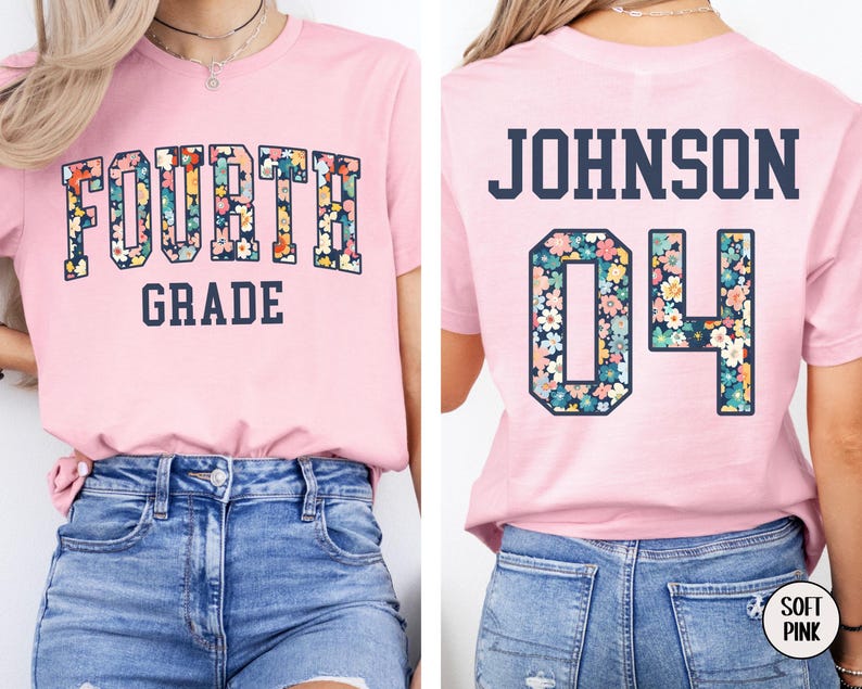 May include: A light pink t-shirt with the words "FOURTH GRADE" in a floral design. The back of the shirt has the name "JOHNSON" and the number "04" in a floral design. The shirt is paired with blue denim jeans.