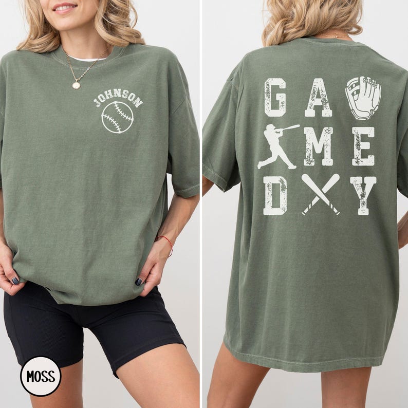 May include: A green t-shirt with the text "GAME DAY" and a baseball player graphic on the back. The front of the shirt has the text "JOHNSON" and a baseball graphic.