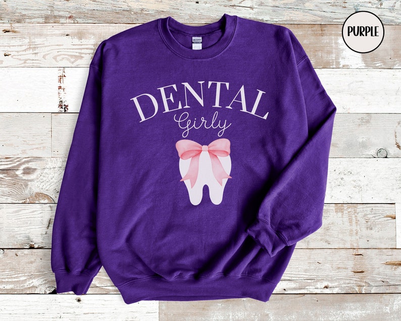 May include: Purple sweatshirt with the text "DENTAL Girly" and a white tooth with a pink bow on it.