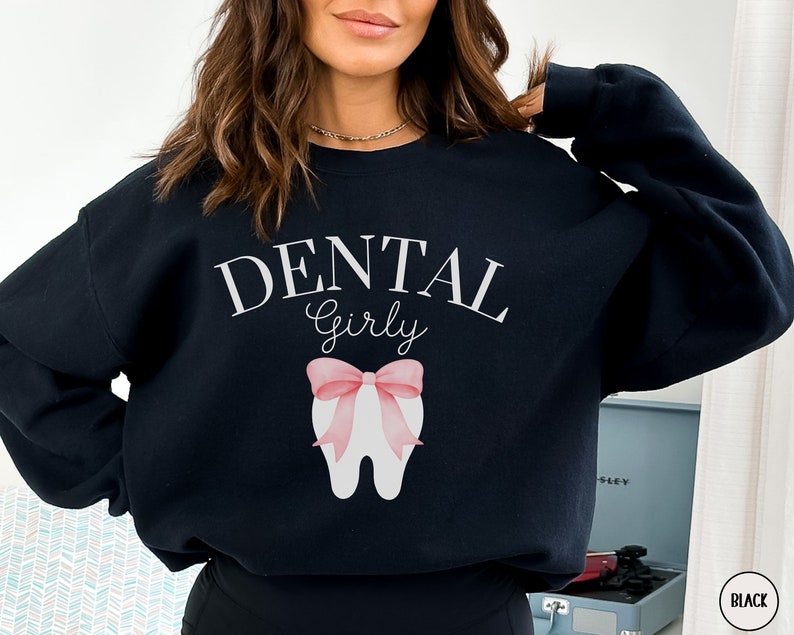 May include: Black sweatshirt with the text "Dental Girly" and a pink bow on a white tooth graphic.