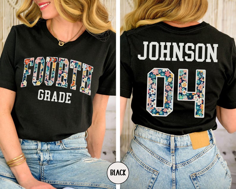 May include: Black t-shirt with "FOURTH GRADE" in floral print lettering on the front. The back of the shirt displays "JOHNSON 04" with floral print accents. The shirt is paired with blue jeans.