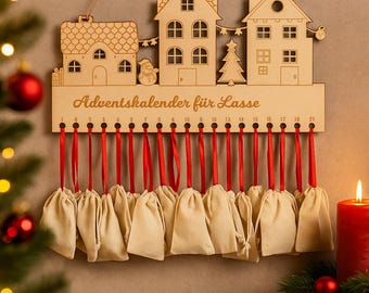 May include: Wooden advent calendar featuring three house cutouts, a snowman, and a Christmas tree. The calendar has 21 numbered holes with red ribbons and attached beige fabric bags. The text "Adventskalender für Lasse" is visible.