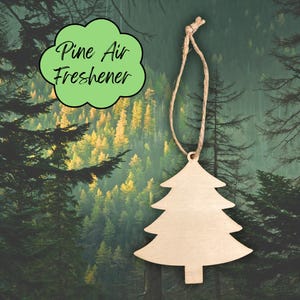 May include: A wooden Christmas tree-shaped air freshener with a natural wood finish, suspended by a twine string. The air freshener is set against a backdrop of a forest scene. The text "Pine Air Freshener" is in a green bubble.