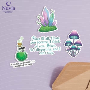 May include: A collection of whimsical stickers featuring a crystal formation, mushrooms, and a potion bottle. The stickers have a fantasy theme with text that reads "Most of all, I hate you because I think of you. Often. It's disgusting, and I can't stop."