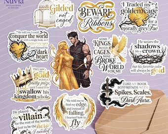 May include: A collection of eleven die-cut stickers featuring fantasy-themed illustrations and quotes. The designs include a golden bird, a crown, a sword, chains, and a couple, with text such as Gilded not caged, Beware the Ribbons, and I Traded my golden cage.