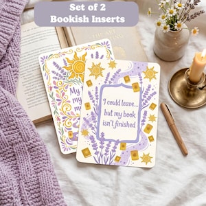 May include: Two bookish inserts with floral and sun designs. One insert reads "My, my, my" and the other says "I could leave... but my book isn't finished." The inserts are on a white surface with a purple sweater and a book.