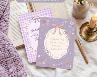 May include: A set of two rectangular bookish inserts featuring lavender and white gingham patterns, floral borders, and bows. One insert displays the text 'Dearest society this', while the other reads 'A proper lady always carries a secret... and a book'.