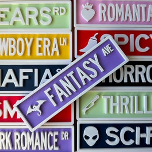 May include: A collection of colorful street signs with white raised lettering. The signs feature various themes like "Fantasy Ave," "Romance," and "Favorite." Each sign has a unique color and design, including a dragon and a heart.
