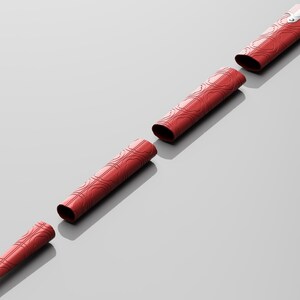 Puede incluir: Un bol&iacute;grafo rojo con una punta plateada se desmonta en cinco piezas. El bol&iacute;grafo tiene un patr&oacute;n decorativo de c&iacute;rculos entrelazados.