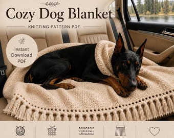 May include: A knitting pattern PDF titled ANNA FLORIDA Cozy Dog Blanket. The image shows a black and tan Doberman dog lying on a beige, textured knit blanket with a decorative eyelet border and fringe. Text includes Instant Download PDF.