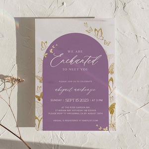 May include: A purple and gold baby shower invitation with a butterfly theme. The invitation reads "We are Enchanted to meet you" and includes the baby's name, date, time, and location. RSVP information is also included.