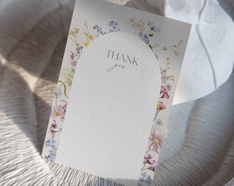 May include: A white card with a floral border and the text "THANK you" in a handwritten font. The card is blank inside and can be used for a variety of occasions.
