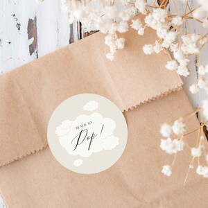 May include: A brown paper bag with a round sticker that says "Ready to Pop!" with a cloud design.
