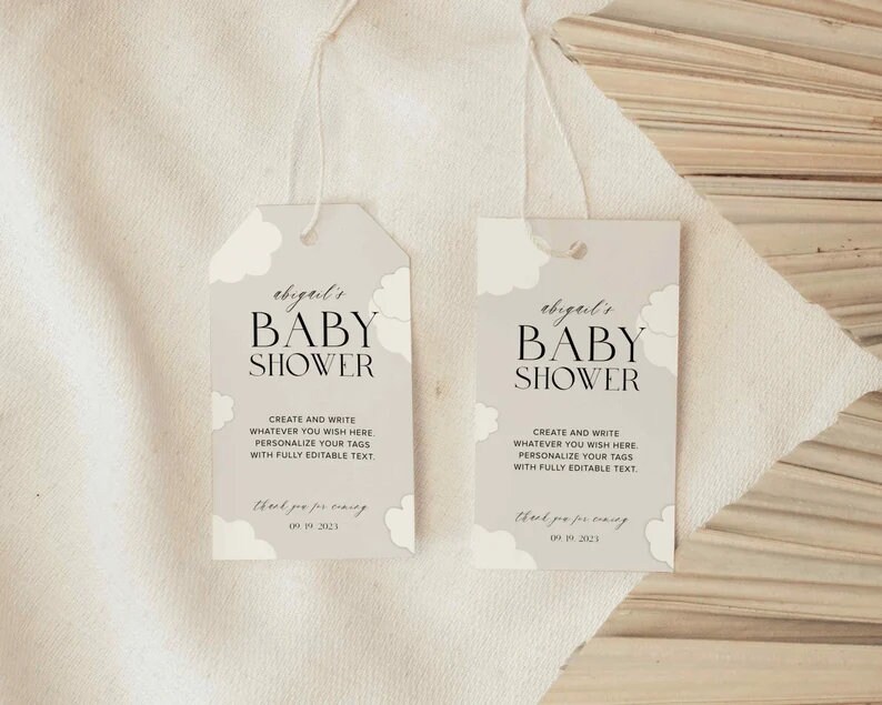 May include: Two light grey baby shower favour tags with white clouds and black text. The text reads "abigail's Baby Shower" and "Create and write whatever you wish here. Personalise your tags with fully editable text. Thank you for coming 09.19.2021".