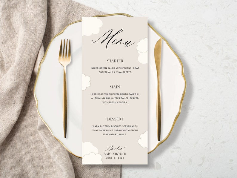 May include: A beige menu card with a cloud design. The menu lists starter, main, and dessert options for a baby shower. The text at the bottom reads "Amelia Baby Shower June 04 2023".
